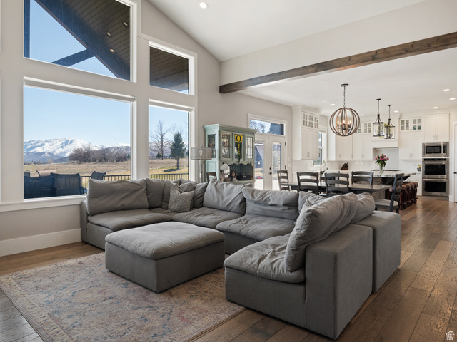 641 West 500 South Midway, UT 84049 - Photo 10 of 52 Expansive living area featuring a vaulted ceiling with exposed wood beams, large picture windows, and wood-finish flooring