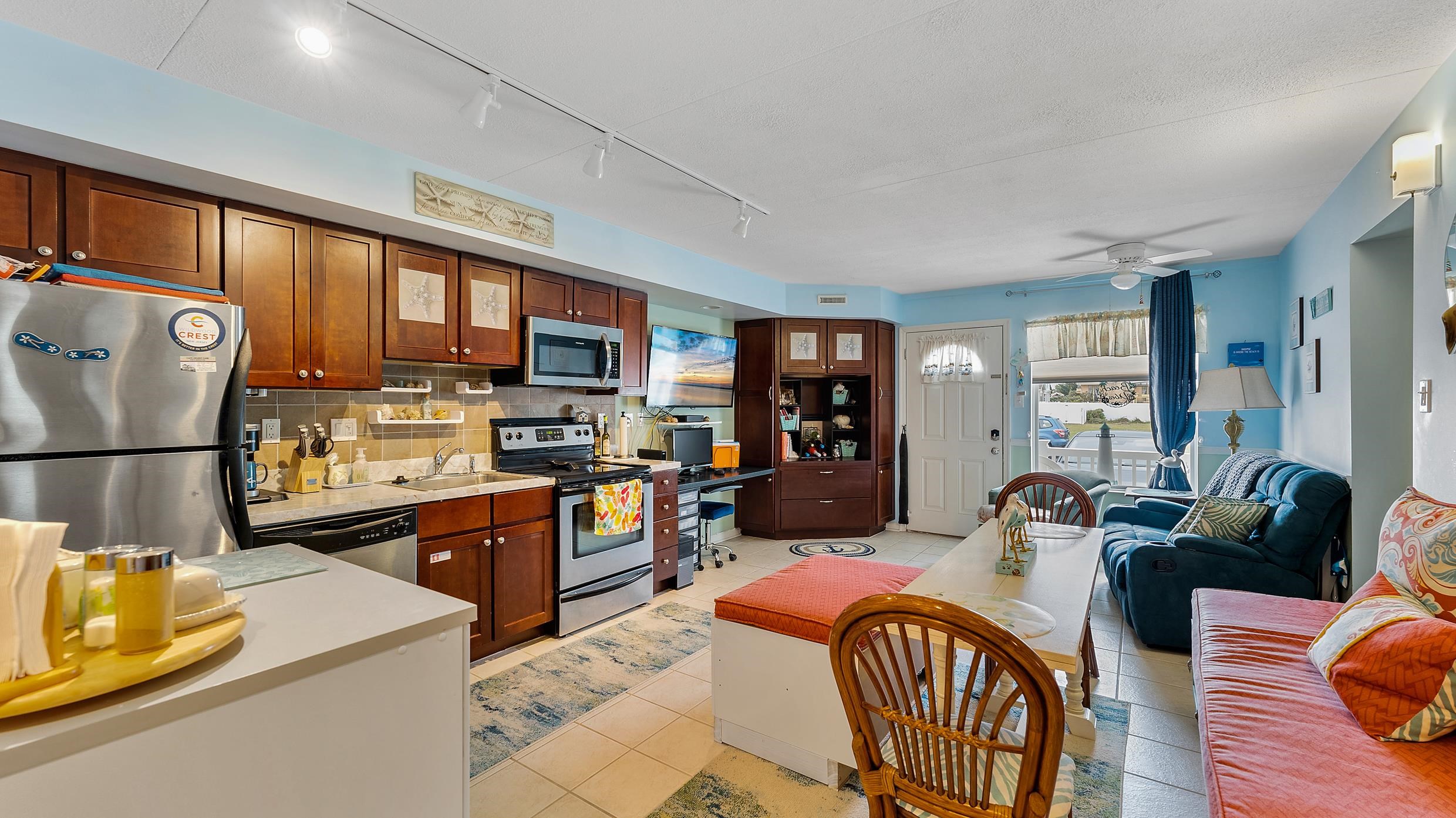 208 East Forget-Me-Not Road, Unit 103 Wildwood Crest, NJ 08260 - Photo 8 of 20 a kitchen with stainless steel appliances granite countertop a refrigerator a stove top oven a dining table and chairs with wooden floor