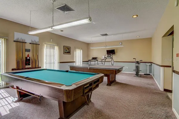 a room with pool table and windows