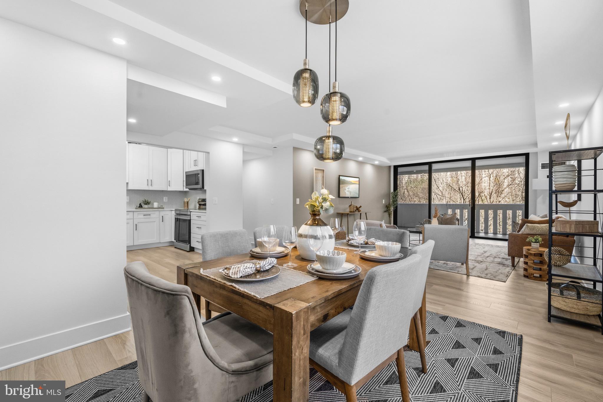6101 Edsall Road, Unit 602 Alexandria, VA 22304 - Photo 2 of 38 a dining room with wooden floor a chandelier a wooden table and chairs