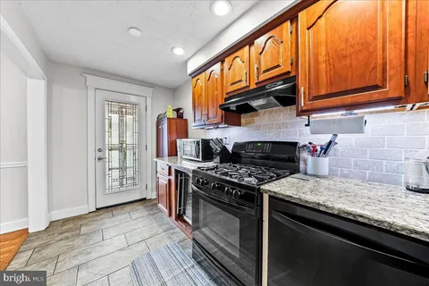 a kitchen with stainless steel appliances granite countertop a stove and a microwave