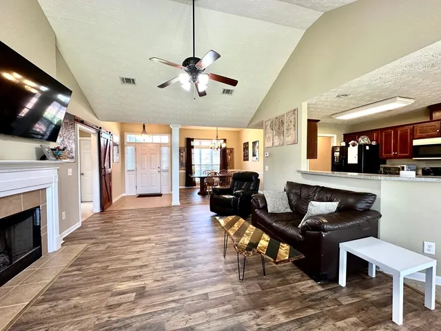 a living room with fireplace furniture and a wooden floor