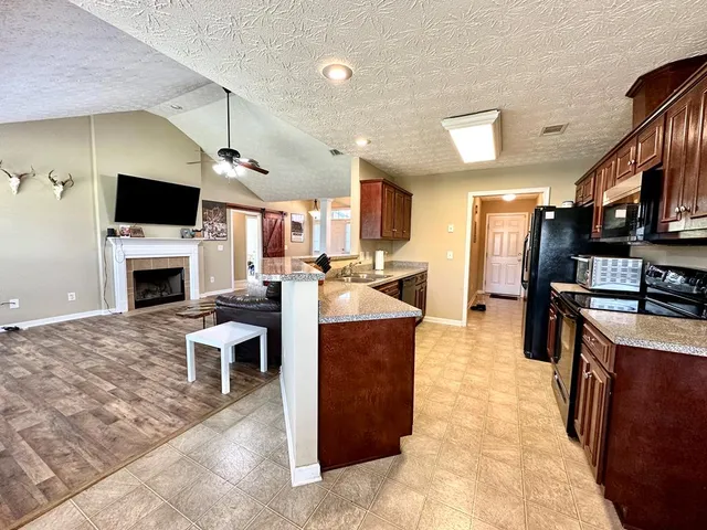 a living room with furniture a flat screen tv and a fireplace