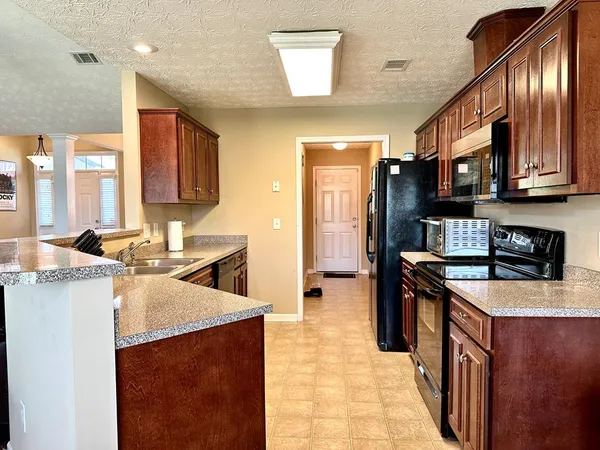 a kitchen with stainless steel appliances granite countertop a stove a sink dishwasher and a refrigerator