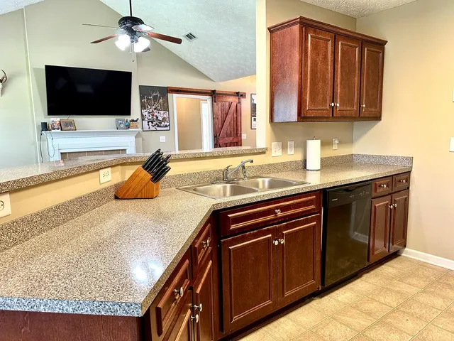 a kitchen with granite countertop a sink and a stove top oven with wooden floor