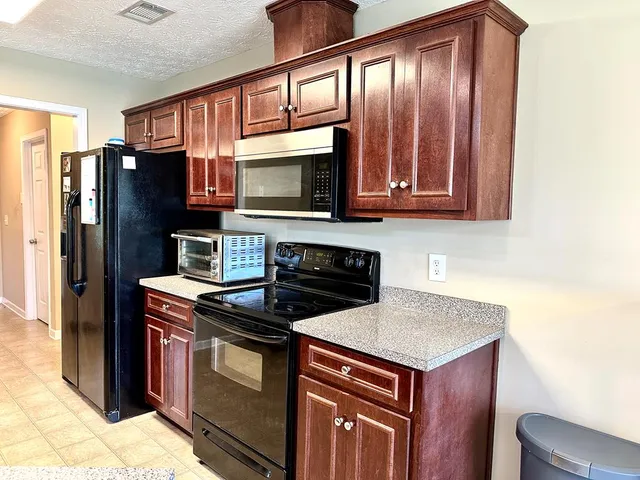a kitchen with stainless steel appliances granite countertop a stove microwave and refrigerator