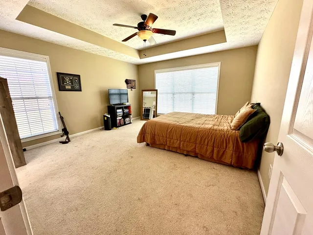 a bedroom with a bed dresser and a window