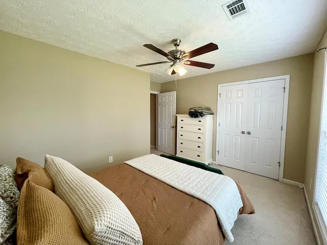 a bedroom with a bed and a ceiling fan