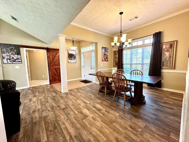 a view of a a dining room with furniture window and wooden floor
