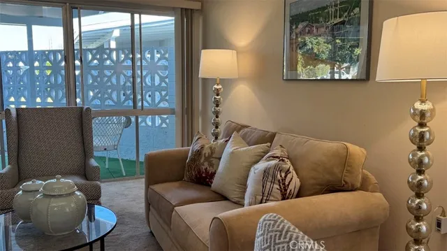 a living room with furniture and a floor to ceiling window