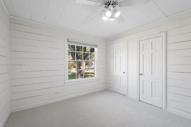 an empty room with closet and chandelier fan