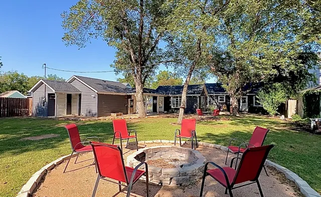 a front view of a house with a garden and trees