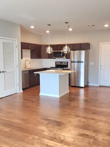 a kitchen with stainless steel appliances a refrigerator and a stove top oven