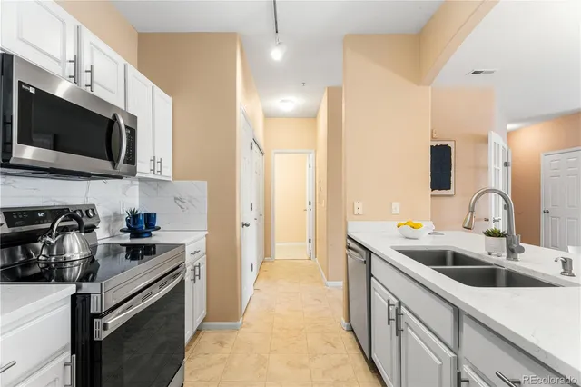 a kitchen with a sink a stove and cabinets