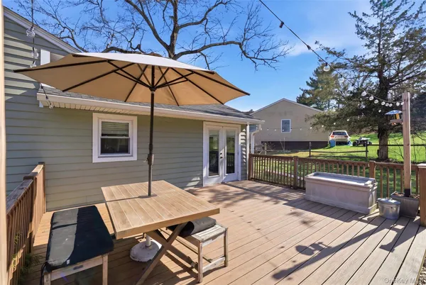 a view of a patio with table and chairs with wooden floor and fence