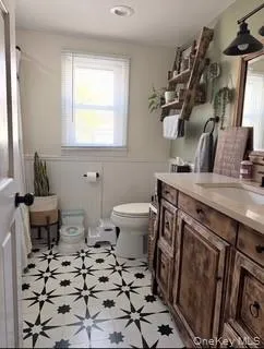 a bathroom with a sink toilet and a mirror