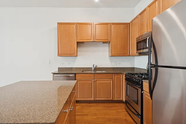 a kitchen with stainless steel appliances granite countertop a refrigerator and a sink