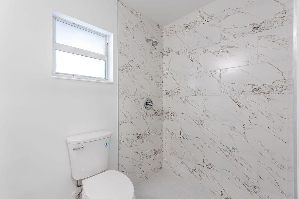3246 Jefferson Street Stuart, FL 34997 - Photo 12 of 19 a white toilet sitting next to a shower