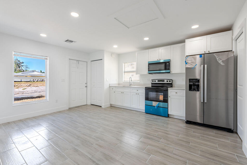 3246 Jefferson Street Stuart, FL 34997 - Photo 3 of 19 a kitchen with stainless steel appliances a refrigerator and a stove top oven