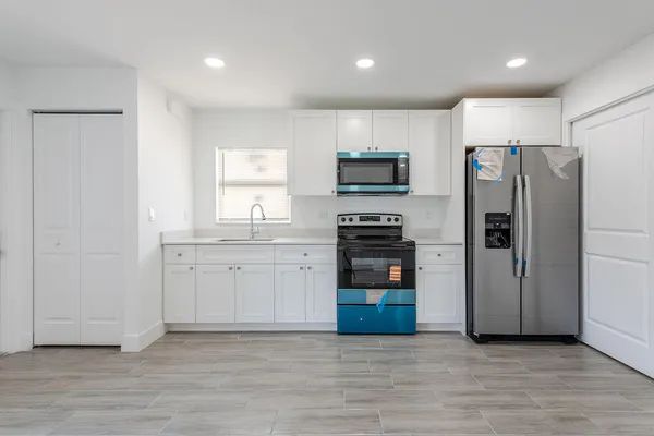 a kitchen with stainless steel appliances a refrigerator and a stove top oven