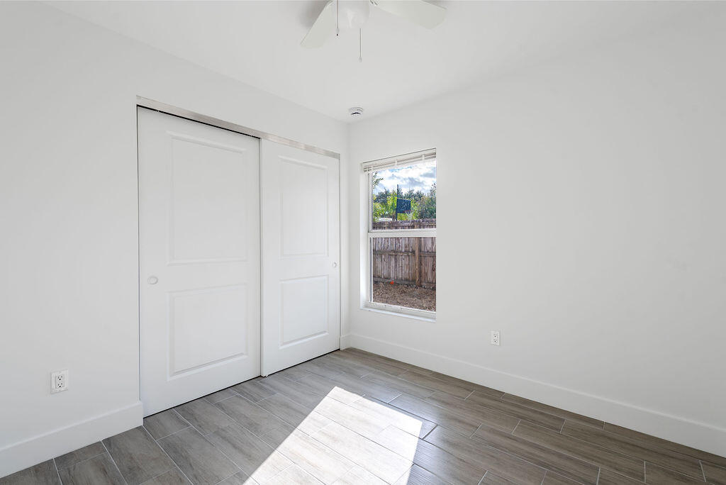 3246 Jefferson Street Stuart, FL 34997 - Photo 10 of 19 an empty room with wooden floor cabinet and windows