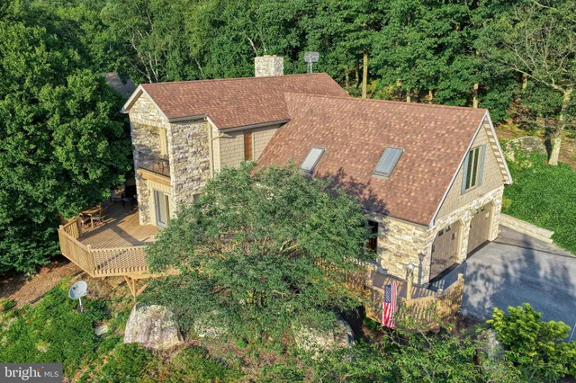 an aerial view of a house with swimming pool and garden