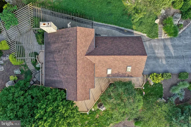 an aerial view of a house with a yard and large trees
