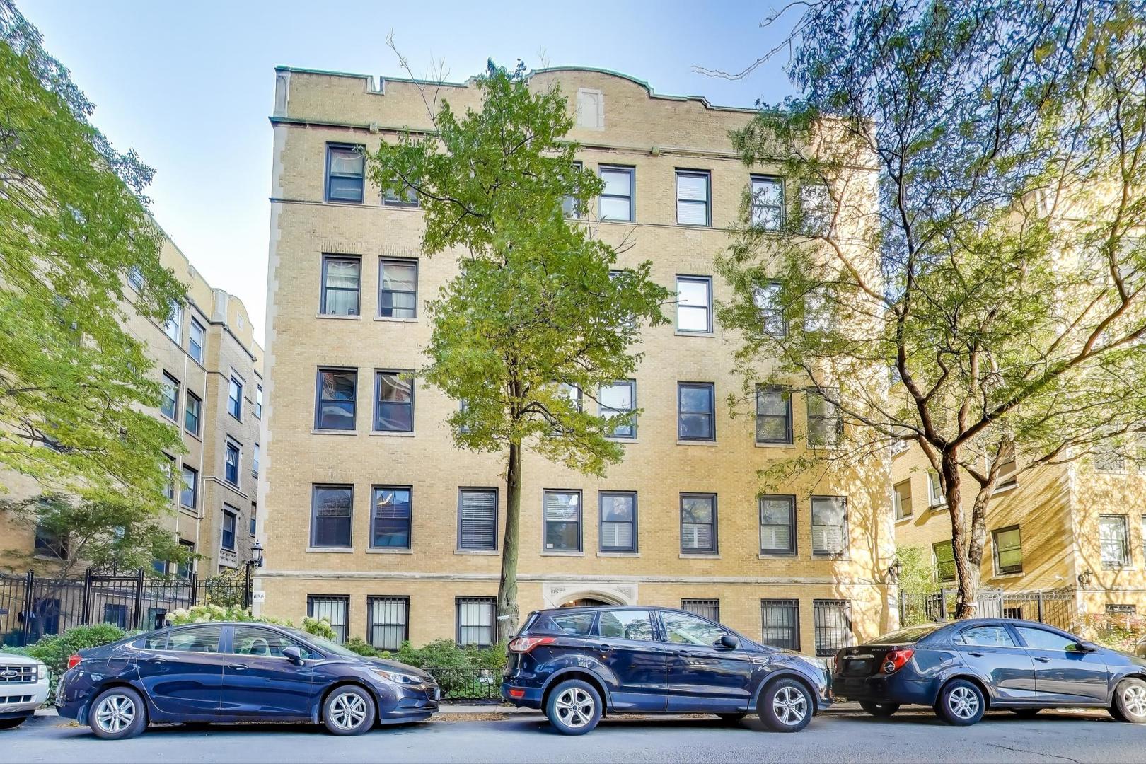 a front view of a residential apartment building with a garden