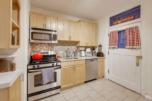 a kitchen with granite countertop cabinets stainless steel appliances and a sink