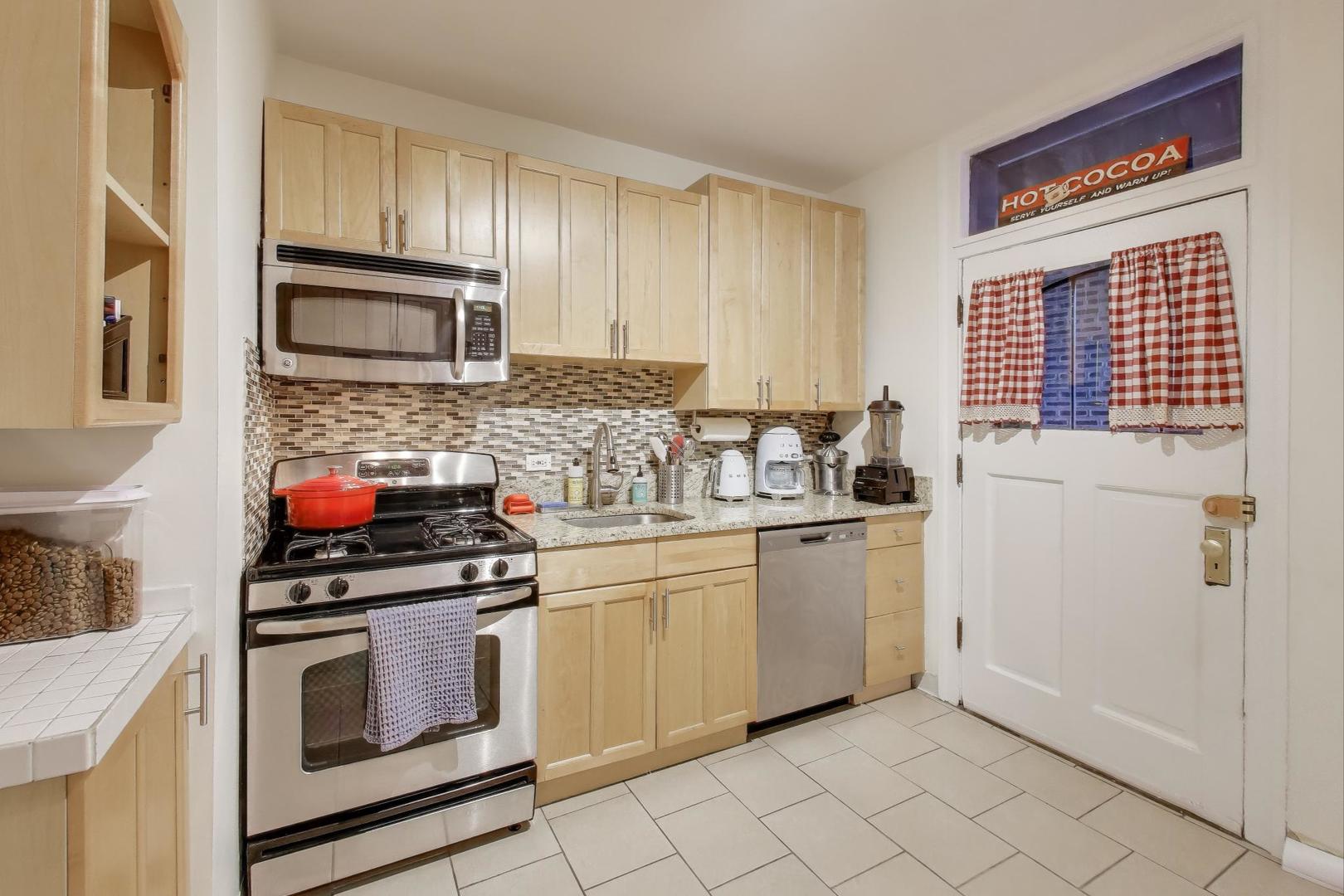 636 West Waveland Avenue, Unit 2E Chicago, IL 60613 - Photo 11 of 23 a kitchen with granite countertop cabinets stainless steel appliances and a sink