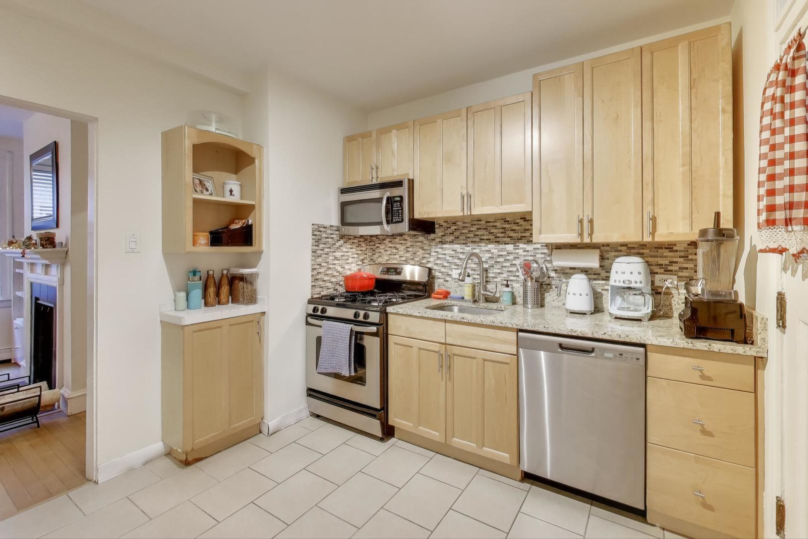 636 West Waveland Avenue, Unit 2E Chicago, IL 60613 - Photo 12 of 23 a kitchen with granite countertop cabinets and stainless steel appliances