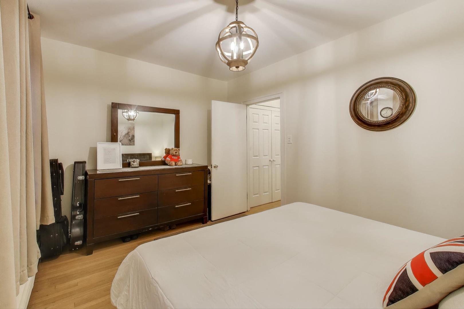636 West Waveland Avenue, Unit 2E Chicago, IL 60613 - Photo 16 of 23 a bedroom with a bed and a chandelier
