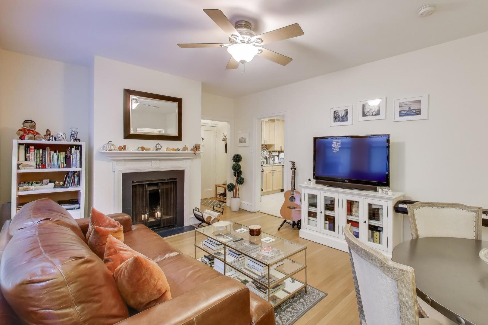 636 West Waveland Avenue, Unit 2E Chicago, IL 60613 - Photo 9 of 23 a living room with furniture a flat screen tv and a fireplace