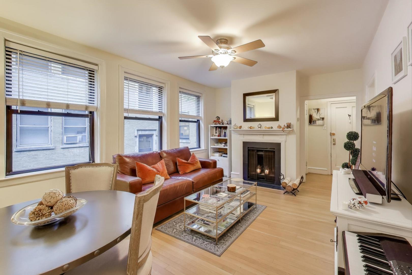 636 West Waveland Avenue, Unit 2E Chicago, IL 60613 - Photo 10 of 23 a living room with furniture flat screen tv and a fireplace