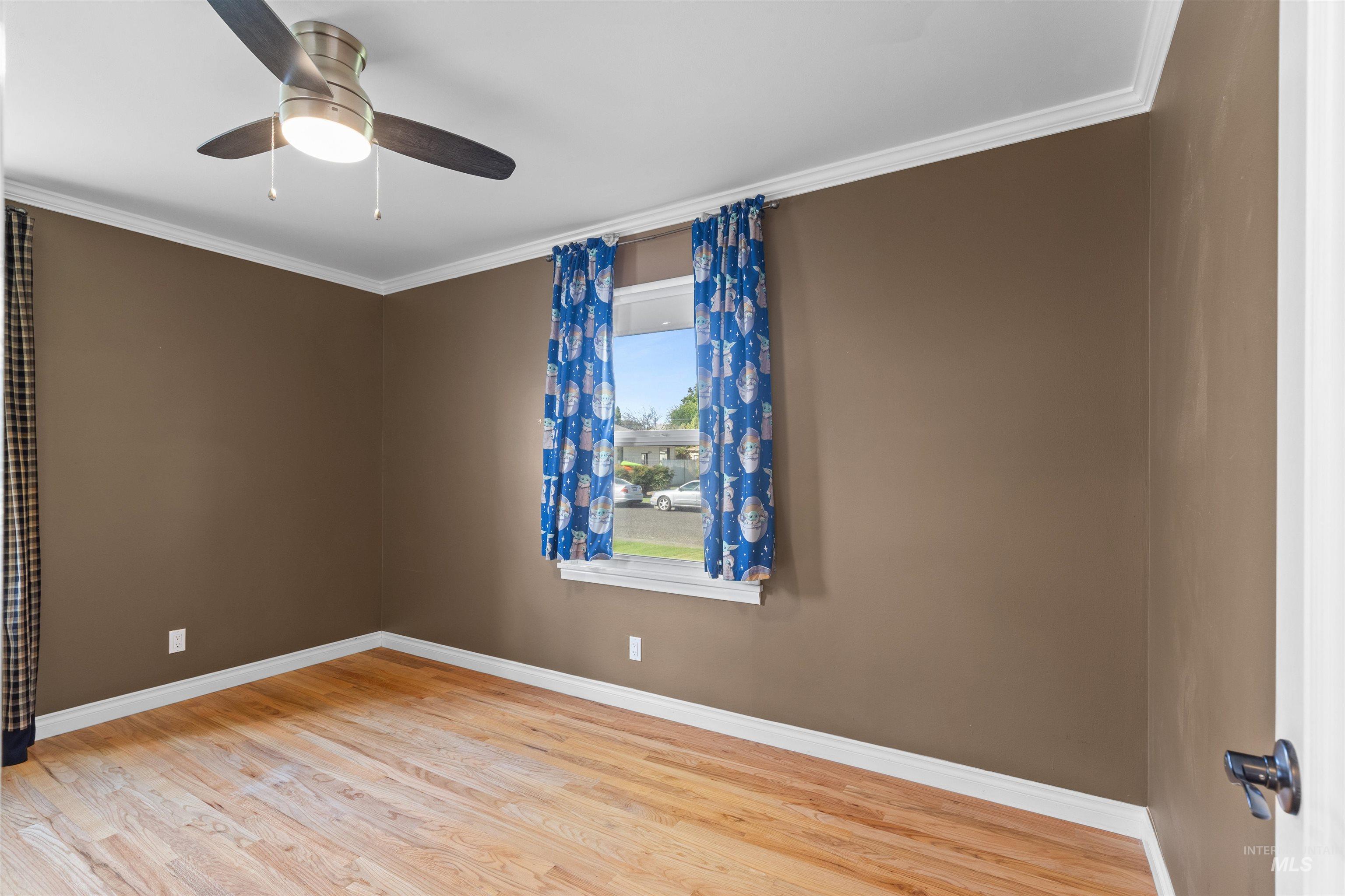 1303 4th Street Clarkston, WA 99403 - Photo 12 of 32 Spare room with crown molding, light wood-style floors, and ceiling fan
