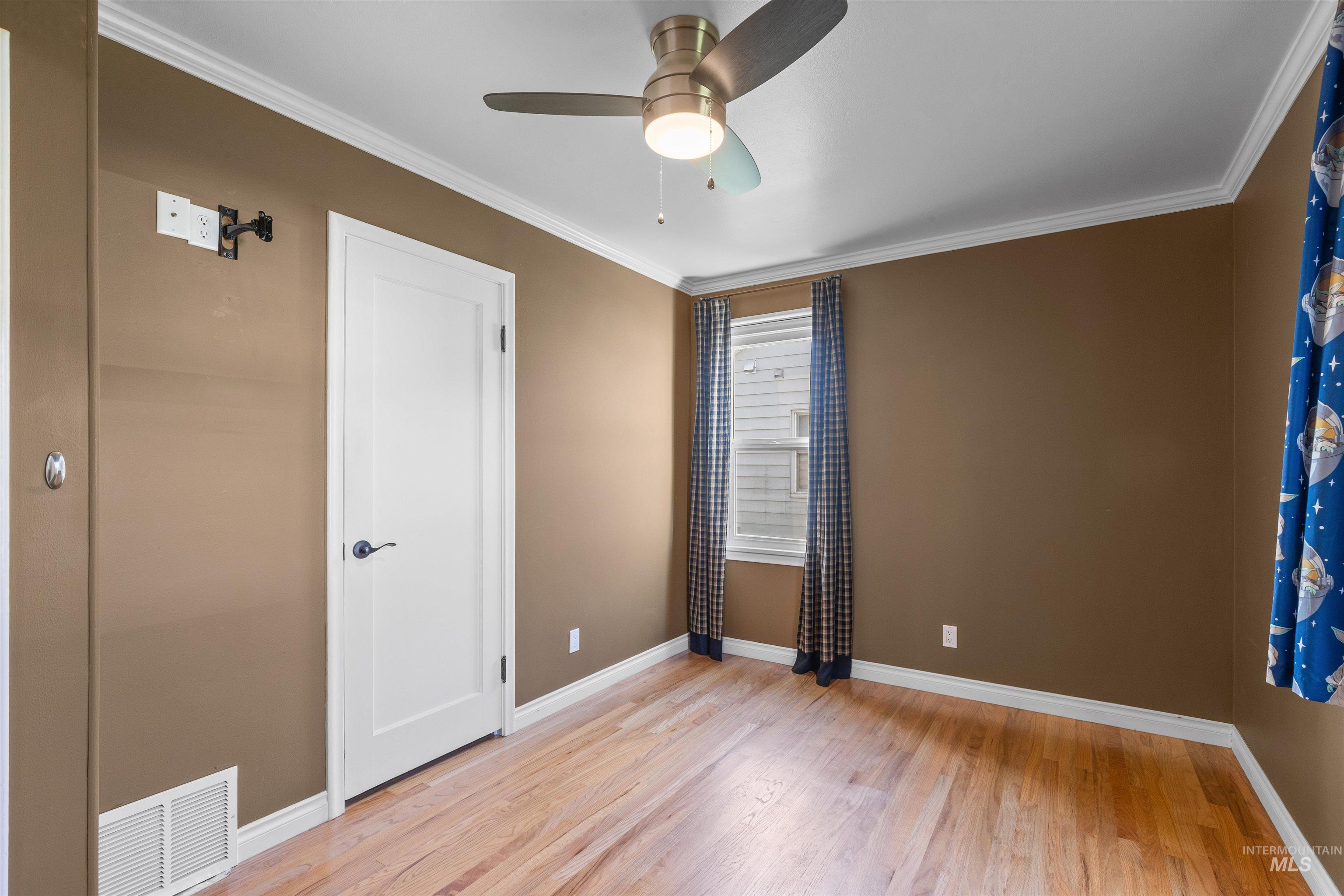 1303 4th Street Clarkston, WA 99403 - Photo 19 of 32 Unfurnished bedroom with ornamental molding, light wood finished floors, and ceiling fan
