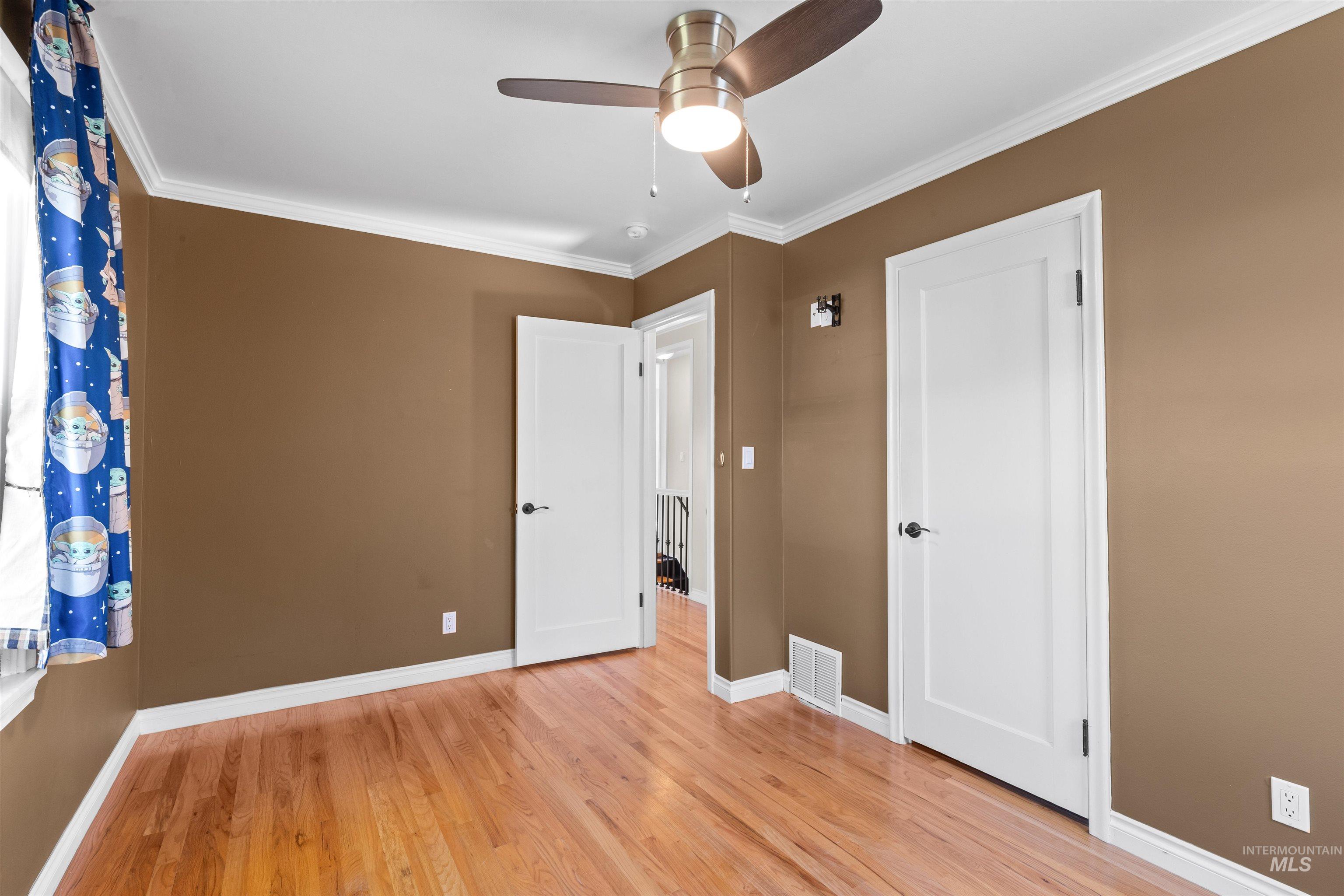 1303 4th Street Clarkston, WA 99403 - Photo 20 of 32 Unfurnished bedroom with ornamental molding, light wood-style flooring, and a ceiling fan