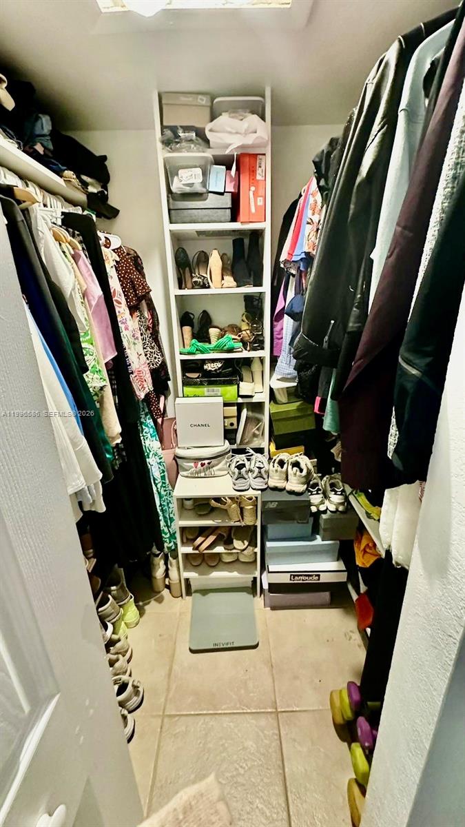 8550 Southwest 109th Avenue, Unit 5101 Miami, FL 33173 - Photo 7 of 8 a view of walk in closet with clothes and shoes