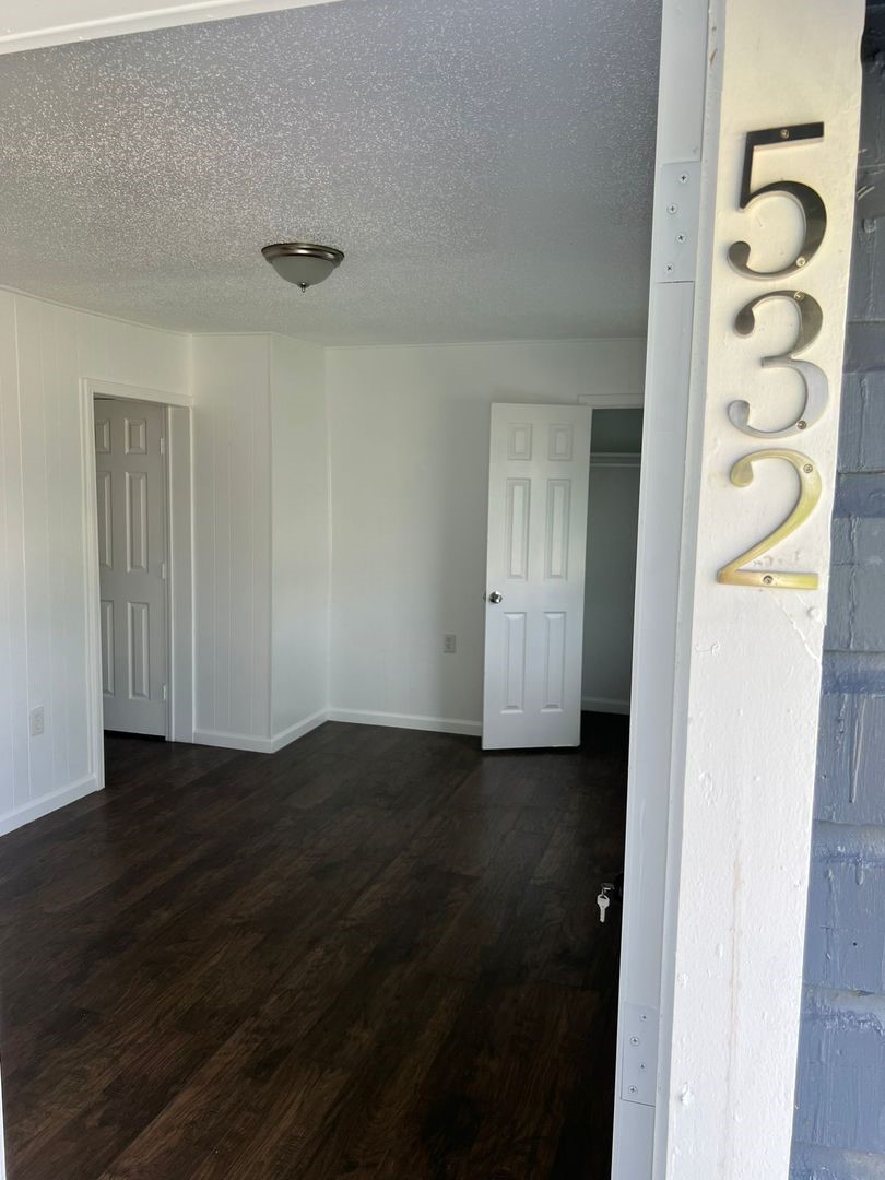 531 East 8th Street Freeport, TX 77541 - Photo 4 of 10 an empty room with wooden floor closet and windows