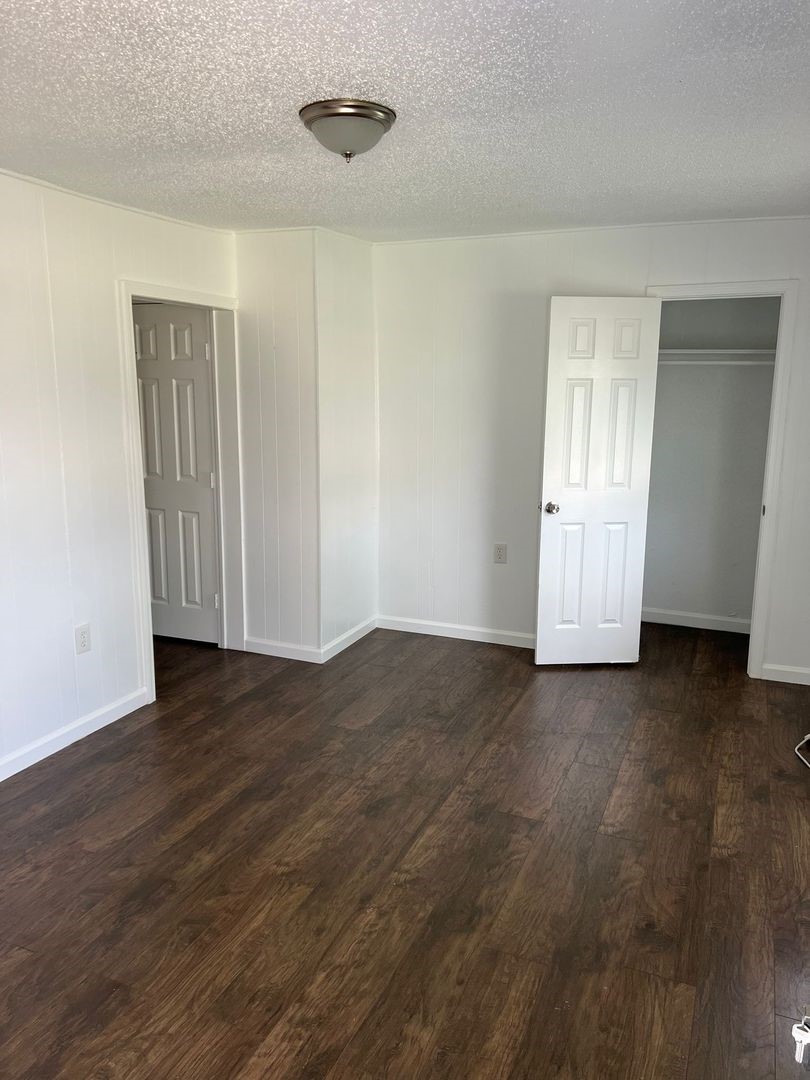 531 East 8th Street Freeport, TX 77541 - Photo 5 of 10 an empty room with wooden floor and windows