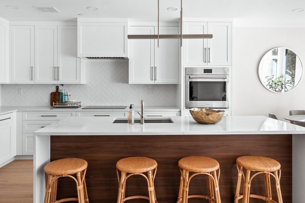 20 Kinmonth Road, Unit 206 Newton, MA 02468 - Photo 6 of 25 a kitchen with stainless steel appliances granite countertop a table chairs sink and cabinets