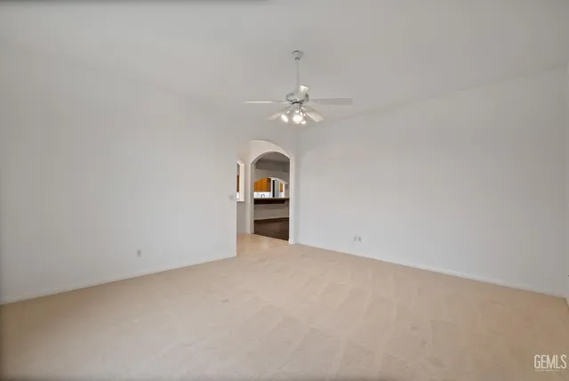 a view of an empty room with wooden floor fireplace and a window