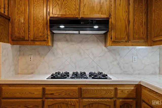 a bathroom with a granite countertop sink a toilet a mirror and shower