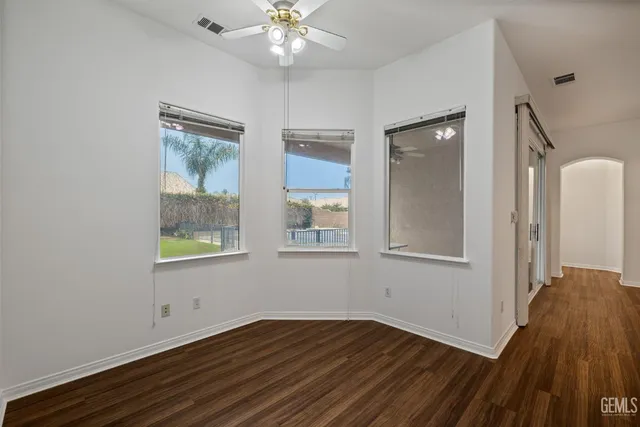 a view of a hallway with wooden cabinets and a bathroom