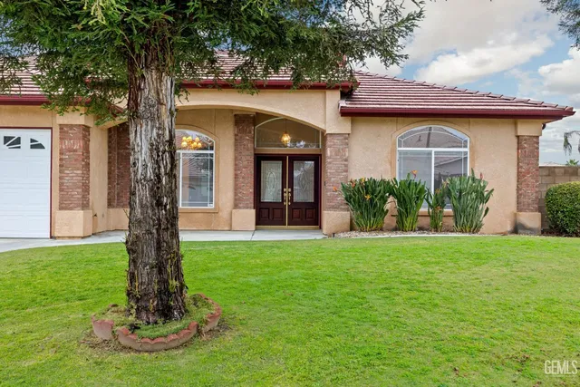 an empty room with wooden floor fireplace and windows