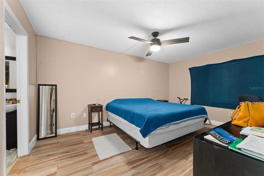 5201 Vineland Road, Unit 112 Orlando, FL 32811 - Photo 13 of 25 a bedroom with a bed and wooden floor