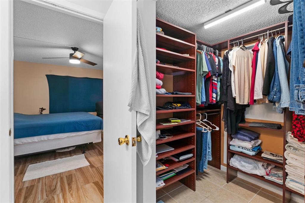 5201 Vineland Road, Unit 112 Orlando, FL 32811 - Photo 14 of 25 a view of walk in closet with clothes and shoes