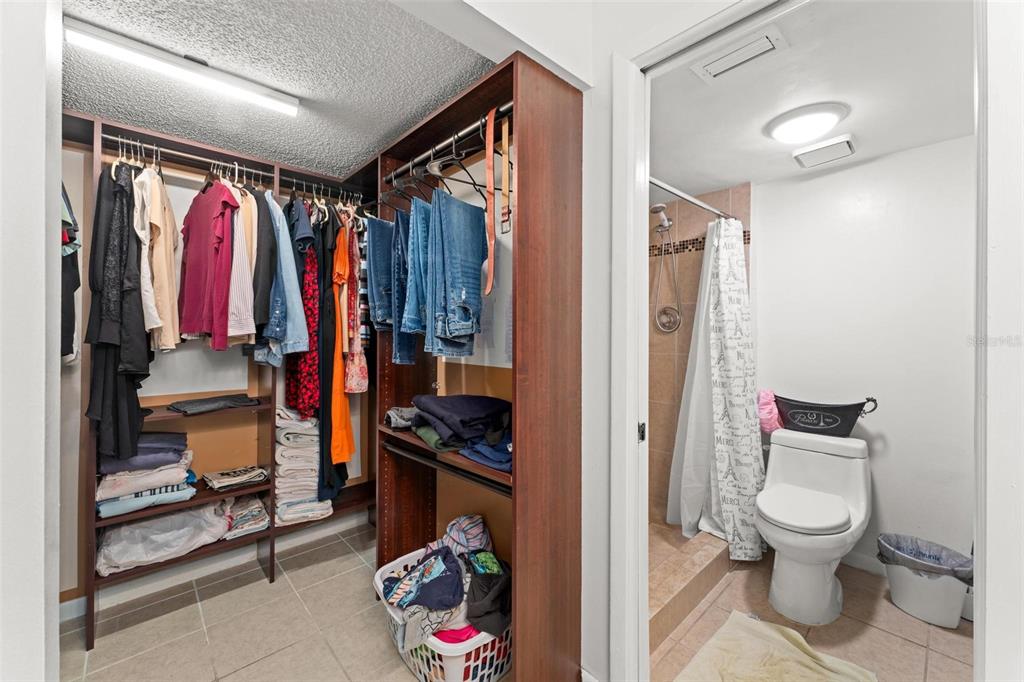 5201 Vineland Road, Unit 112 Orlando, FL 32811 - Photo 16 of 25 a view of walk in closet with clothes and shoes