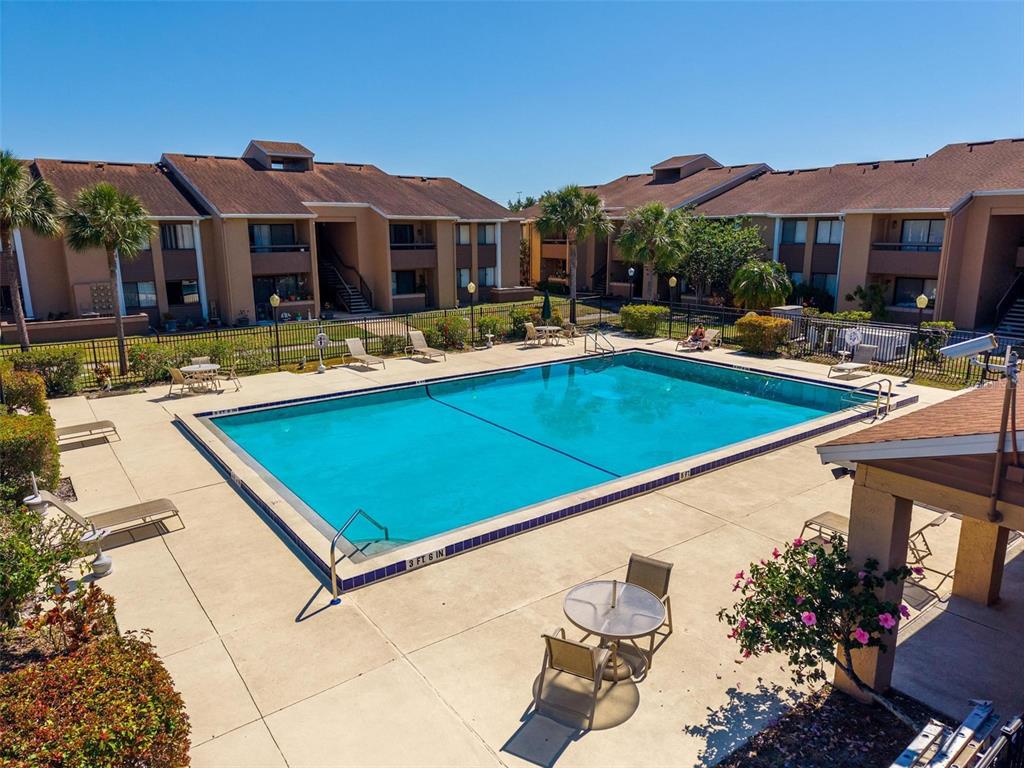5201 Vineland Road, Unit 112 Orlando, FL 32811 - Photo 19 of 25 a view of a patio with swimming pool and a chairs and tables