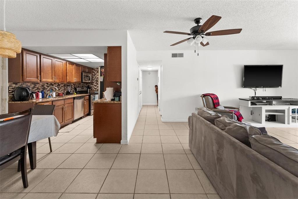 5201 Vineland Road, Unit 112 Orlando, FL 32811 - Photo 3 of 25 a kitchen with a stove a refrigerator and a dining table